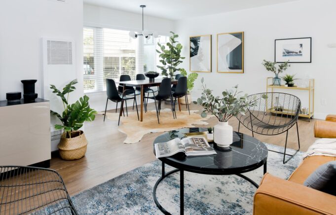 Image of apartment living room and dining area with wood-look plank flooring and 3 large windows