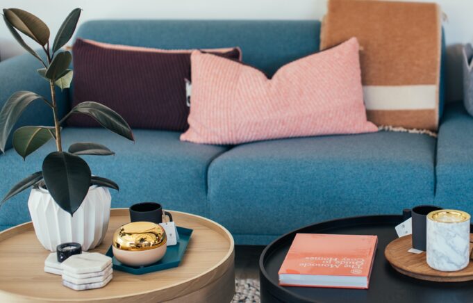 Stock image of a couch with throw pillows and a coffee table with plant.